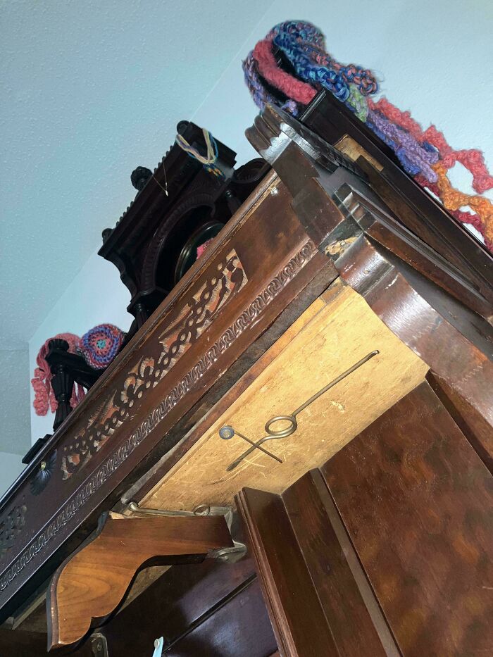 Antique wooden cabinet with intricate carvings and colorful knitted yarn, showcasing interesting tools that solve annoying problems.