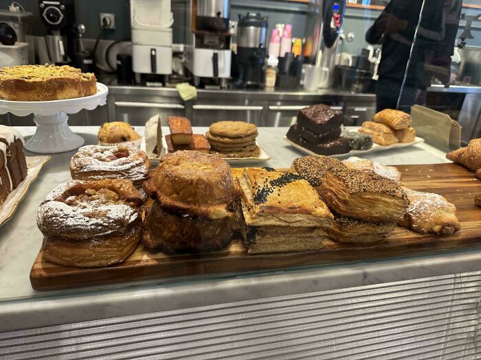 Assorted baked goods and pastries displayed on wooden boards in a bakery showcasing lazy day treats.