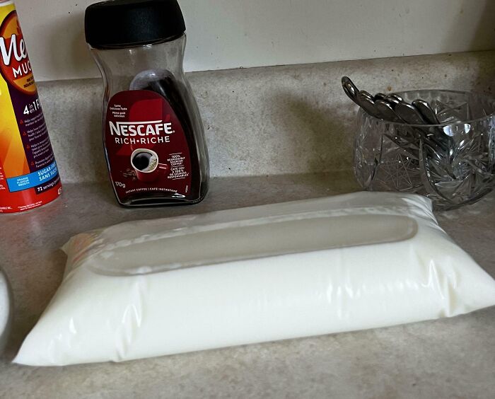 Plastic bag filled with milk resting on kitchen counter, illustrating lazy life hacks from people who are extremely lazy.