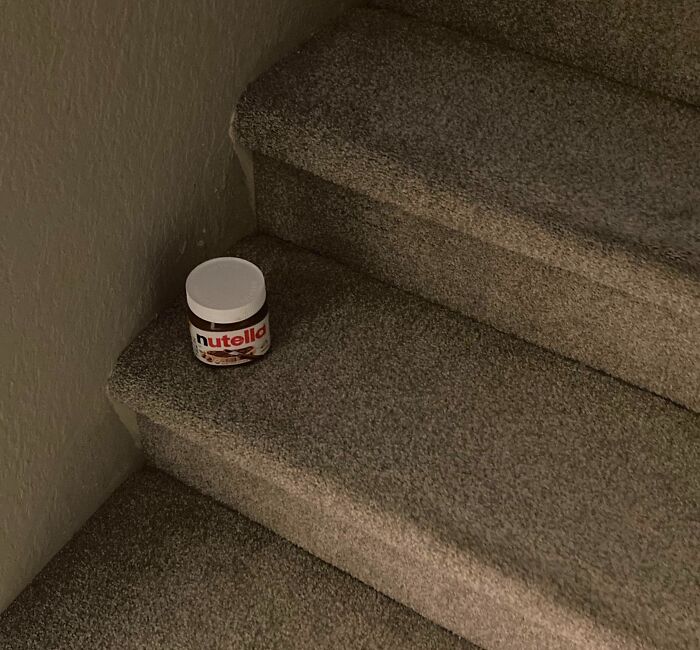 Jar of Nutella left on carpeted stairs showing lazy behavior in a humorous way, fitting the lazy people theme.