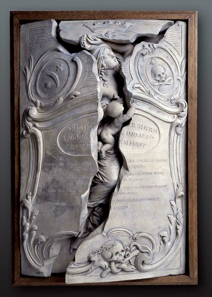 Intricately carved antique relief sculpture depicting a woman and child, an almost perfectly preserved historic artifact.
