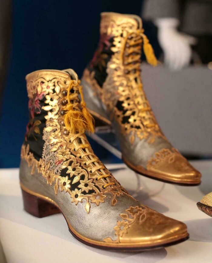 Antique embroidered boots with gold floral details, showcasing almost perfectly preserved craftsmanship from history.