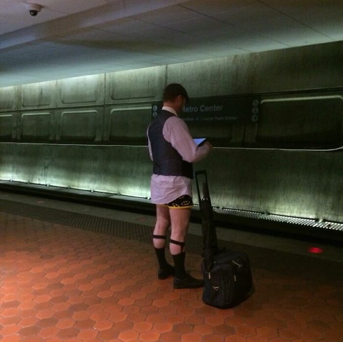 Man in vest and dress shirt with no pants waiting on subway platform, illustrating weird moments on NYC subway.