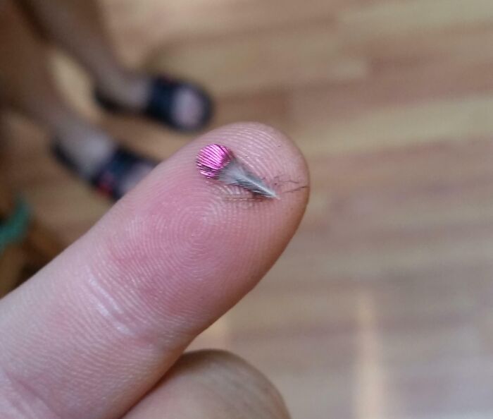 Close-up of a tiny pink water droplet on a fingertip highlighting nature pics with detailed beauty and interest.