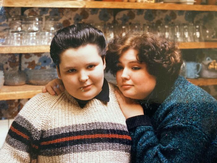 Two people with iconic 80s hairdos posing together indoors, showcasing vintage hairstyles from the 1980s era.