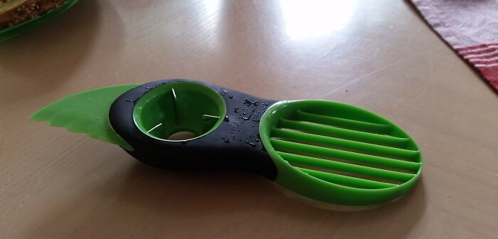 Green and black kitchen tool with slots and a circular hole designed to solve an annoying little problem.