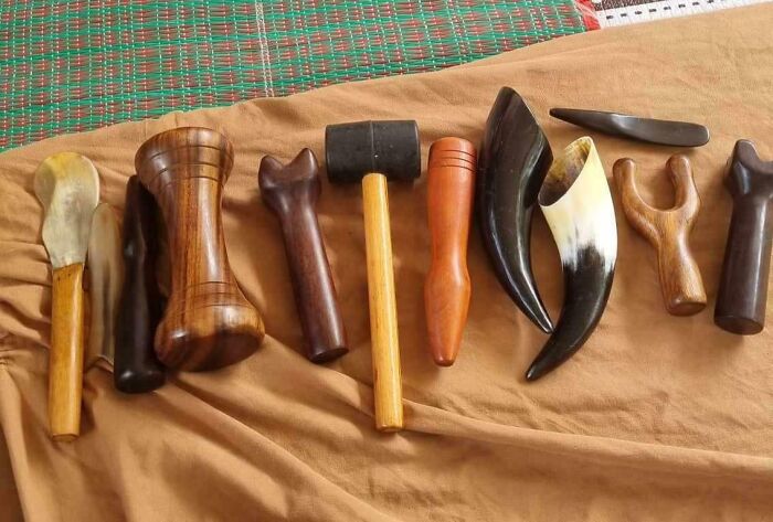 Various interesting tools made of wood and horn laid out on fabric, showcasing unique handcrafted problem-solving designs.