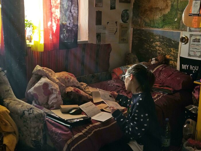 Woman reading documents by a window with natural light, evoking an Accidental Renaissance scene.