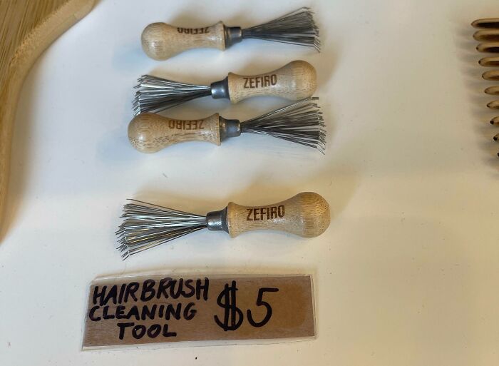 Hairbrush cleaning tools with wooden handles and metal bristles displayed for sale at five dollars each.