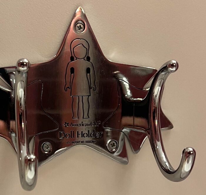 Metal doll holder with three hooks mounted on star-shaped base, a tool that might solve an annoying little problem.