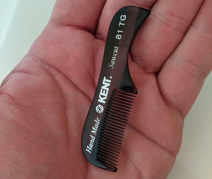 Small black handmade Kent hair comb held in palm, an interesting tool that might solve an annoying little problem.