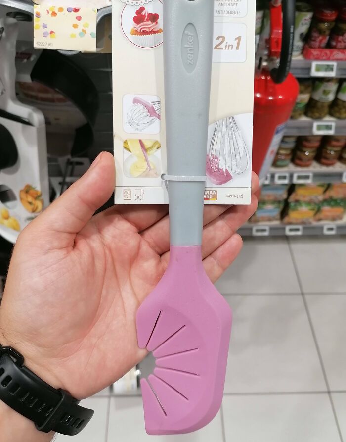 Hand holding a 2-in-1 kitchen tool with a pink silicone spatula head, showcasing interesting tools for small problems.