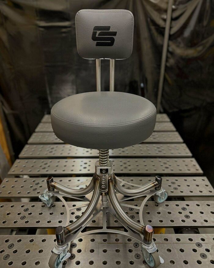 Ergonomic metalworker chair with intricate metal base and caster wheels showcasing remarkable craftsmanship.