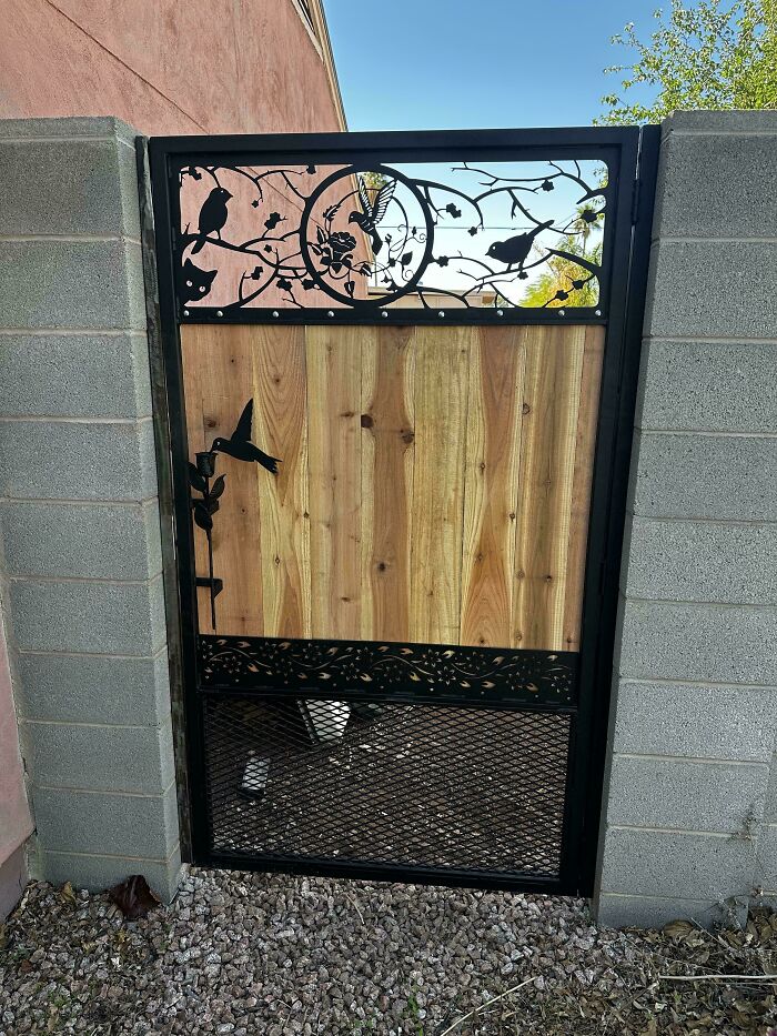 Decorative metalwork gate with intricate bird and branch designs, showcasing metalworkers defying physics and logic.