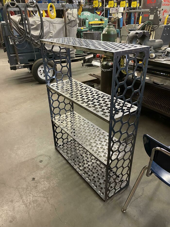 Metalworkers workshop with a uniquely designed perforated metal shelving unit showcasing remarkable crafting skills.