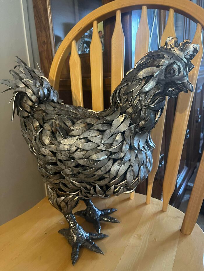 Metal sculpture of a chicken made by metalworkers showcasing remarkable craftsmanship and creativity in metalworking.