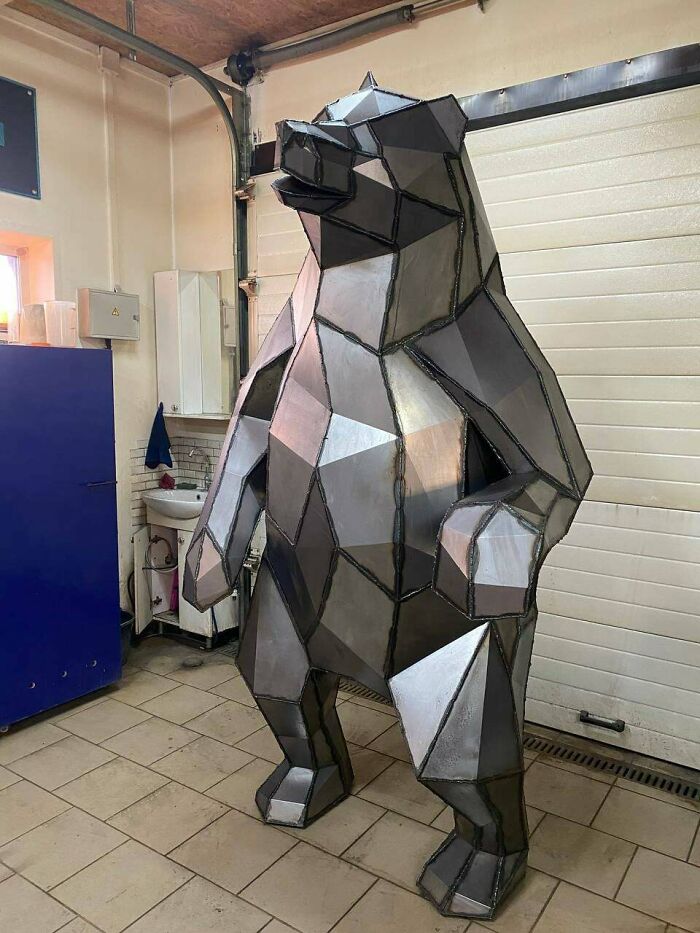 Geometric metal bear sculpture in workshop showcasing remarkable metalworkers' craftsmanship defying physics and logic.