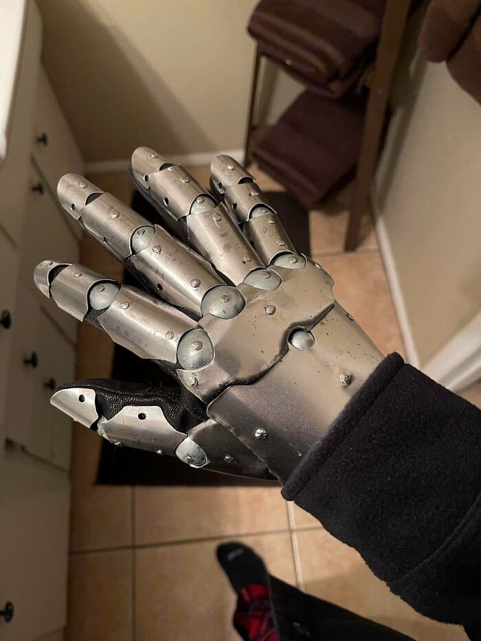 Metalworker-crafted articulated metal glove showcasing remarkable craftsmanship and defying conventional physics with intricate design.