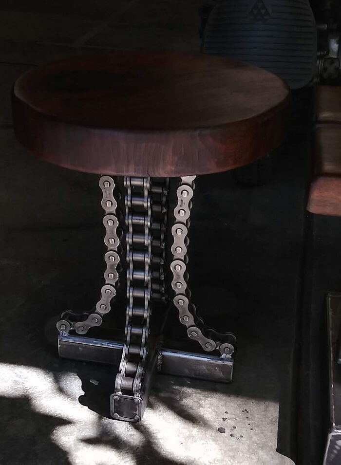 Metalworker crafted a unique stool with intricate metal chain legs supporting a wooden round seat, showcasing remarkable skill.