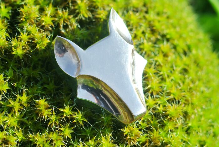 Polished metal artwork shaped like an animal head, showcasing remarkable skill of metalworkers in creative design.