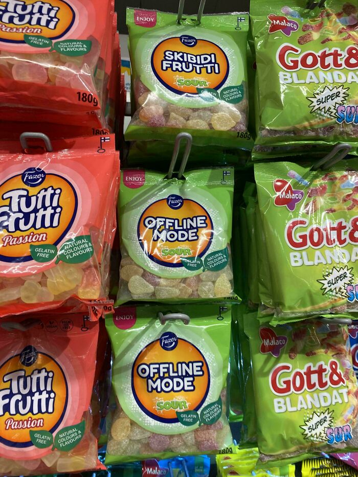 Assorted bags of sour candy including Tutti Frutti, Offline Mode, and Gott & Blandat on store shelves.