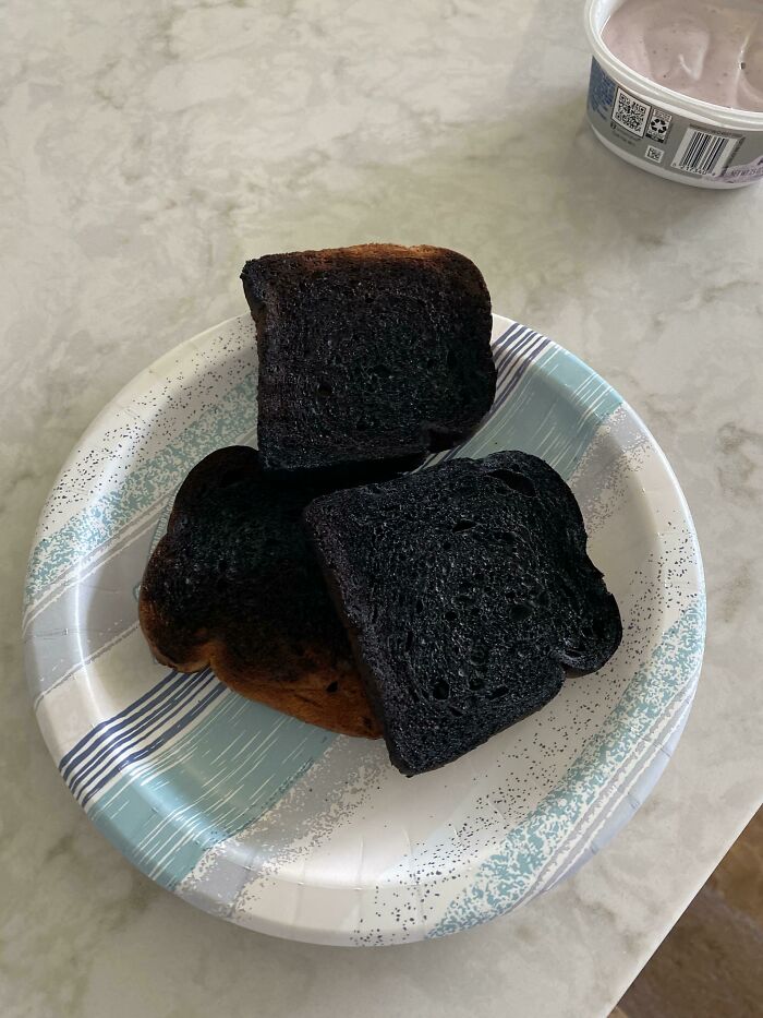 Three slices of burnt toast on a paper plate, illustrating dangerous odors you should never dismiss in daily life.