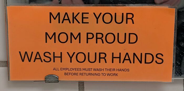 Strange sign in black text on orange background humorously urging employees to wash their hands before returning to work.