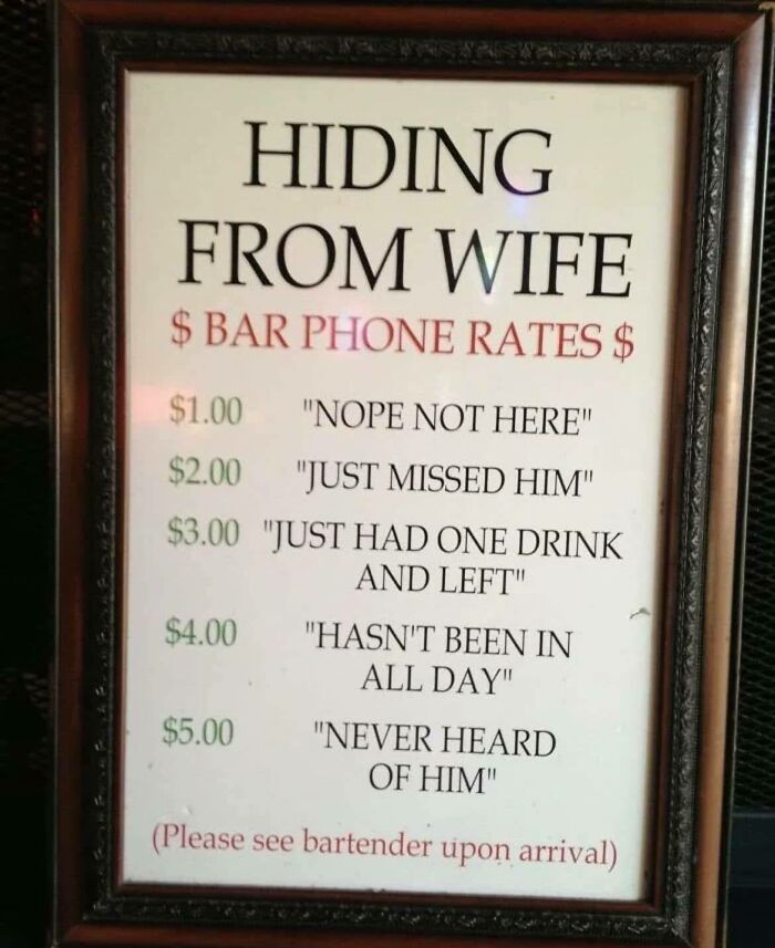 Framed funny sign listing bar phone rates with humorous excuses for hiding from wife in a pub setting.