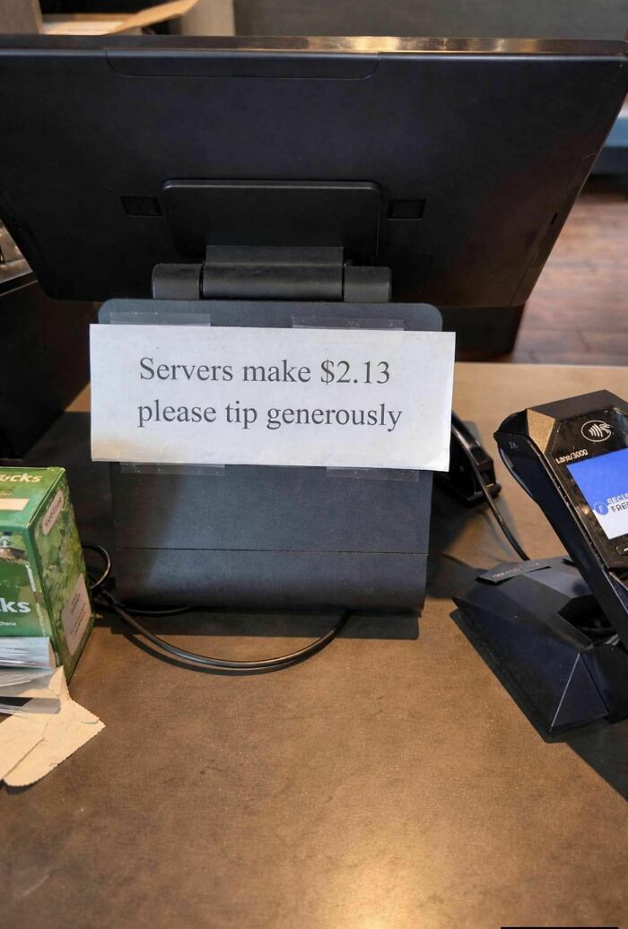 Tip sign at a cash register showing servers make only $2.13 asking customers to tip generously, a strange sign example.