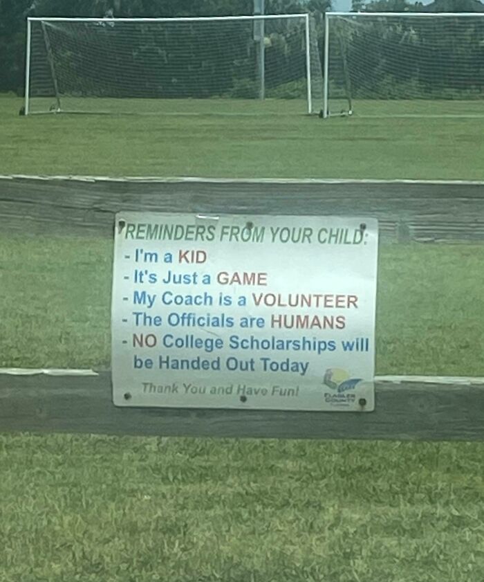 A strange sign at a soccer field reminding parents that the game is just for kids and no scholarships are given.