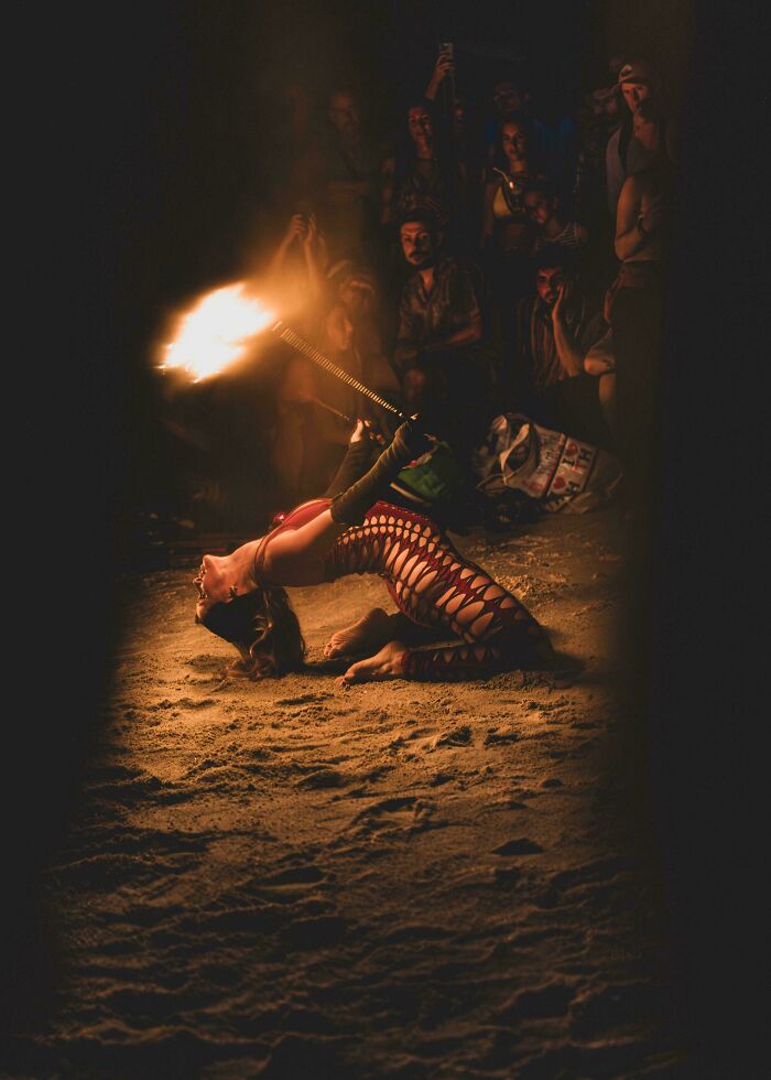 Fire dancer arching back in dramatic lighting, Accidental Renaissance style