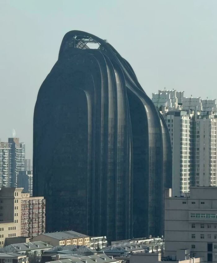 A unique, dark, curved skyscraper that looks like a modern building for an evil mastermind's world domination plans.