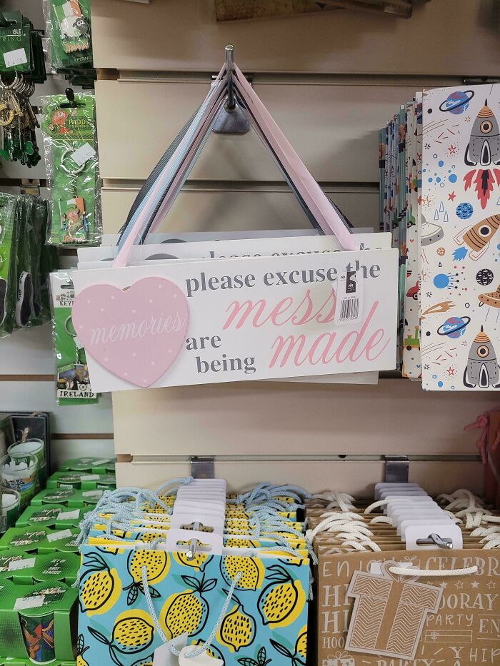 Product design fail with a sign that confusingly says "please excuse the mess made memories," highlighting terrible product designs.