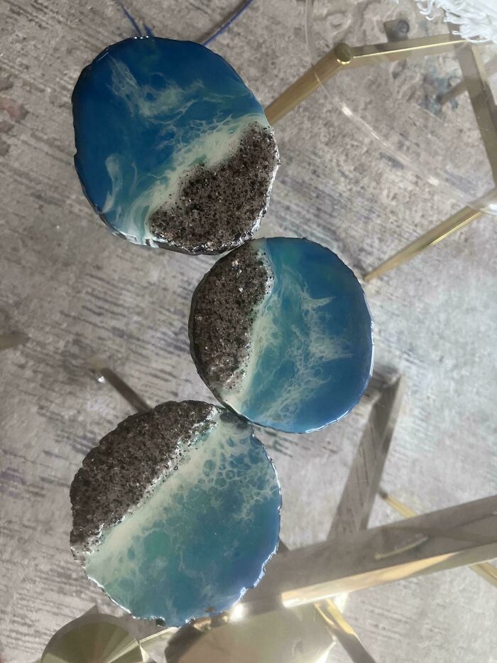 Set of three round tables with ocean wave designs and rough textured surfaces, showcasing terrible product designs.