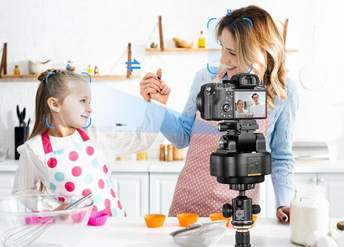 A camera on a tripod recording a mother and daughter baking together, illustrating terrible product designs.