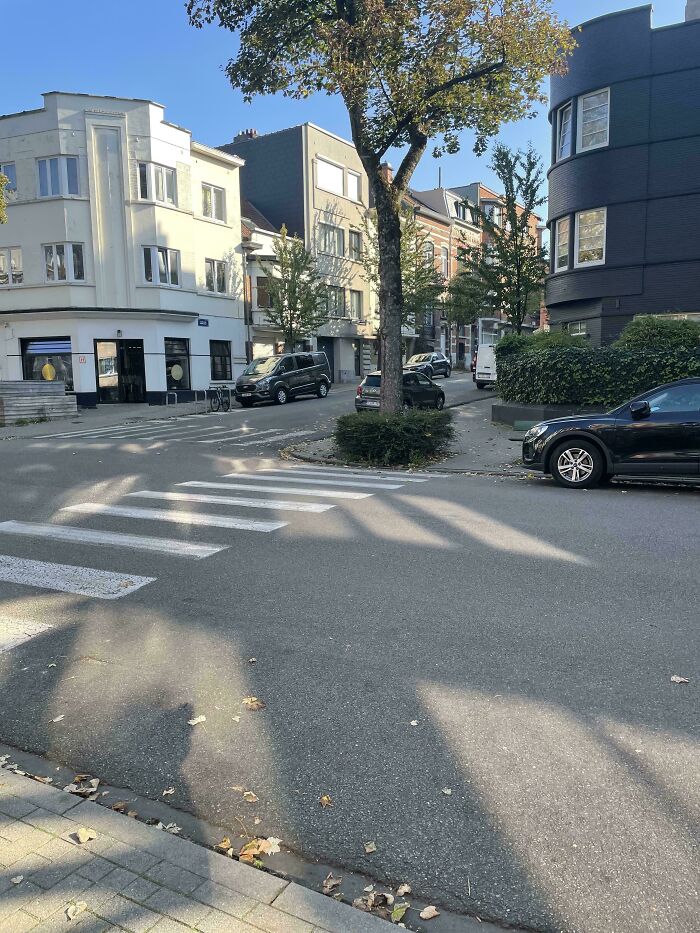 Poorly designed pedestrian crossing with incomplete lines in a residential area, showing terrible product design flaws.