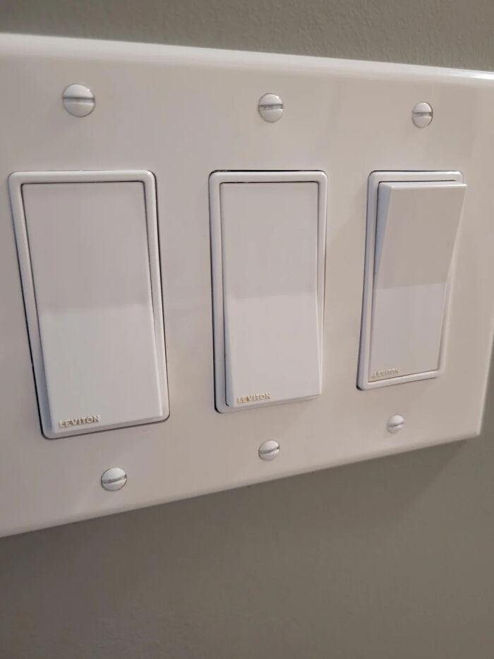 Three white light switches with identical design creating confusion in terrible product designs that should have never seen the light.