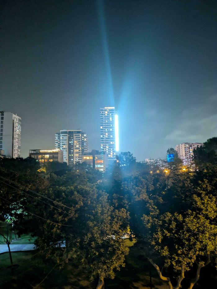 Cityscape at night with illuminated buildings and trees, showcasing lighting as a terrible product design example.