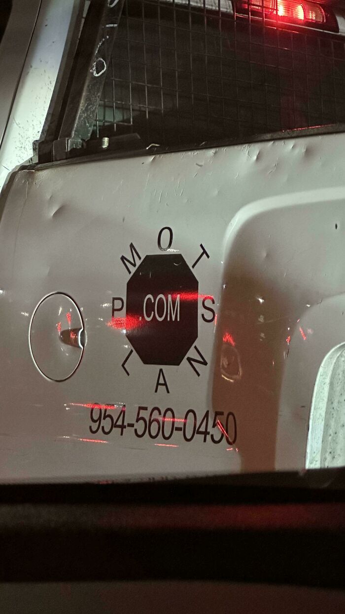 Dent marks on white vehicle door with confusing circular logo and phone number, example of terrible product design fail.