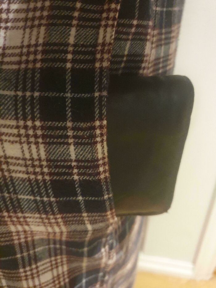 Plaid shirt with a pocket design flaw where a black wallet is partially hidden, illustrating terrible product designs.