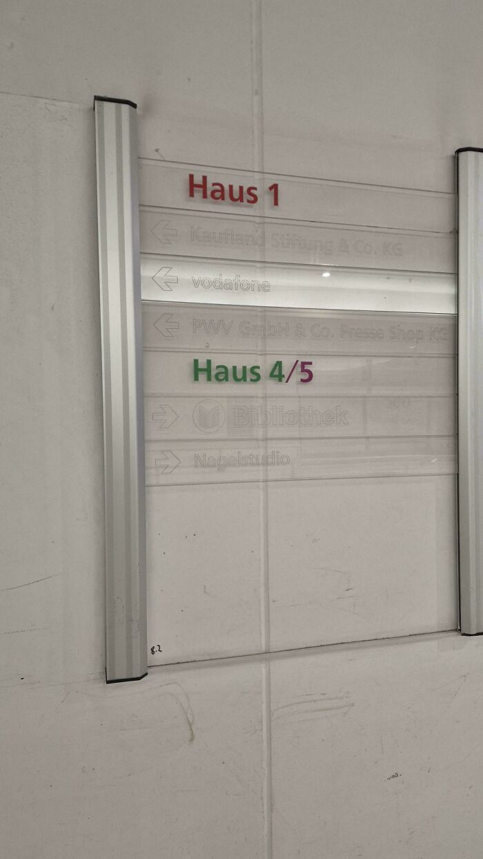 Faded and barely visible building directory sign showing poor product design and usability issues.