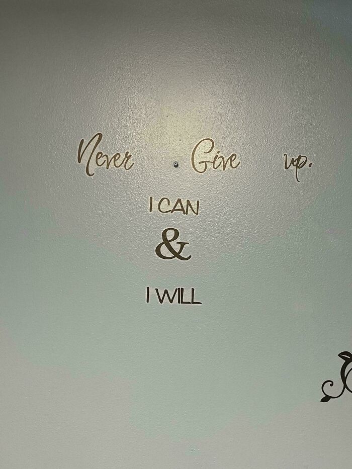 Wall decal with badly placed s***w separating the phrase never give up, showing a terrible product design fail.