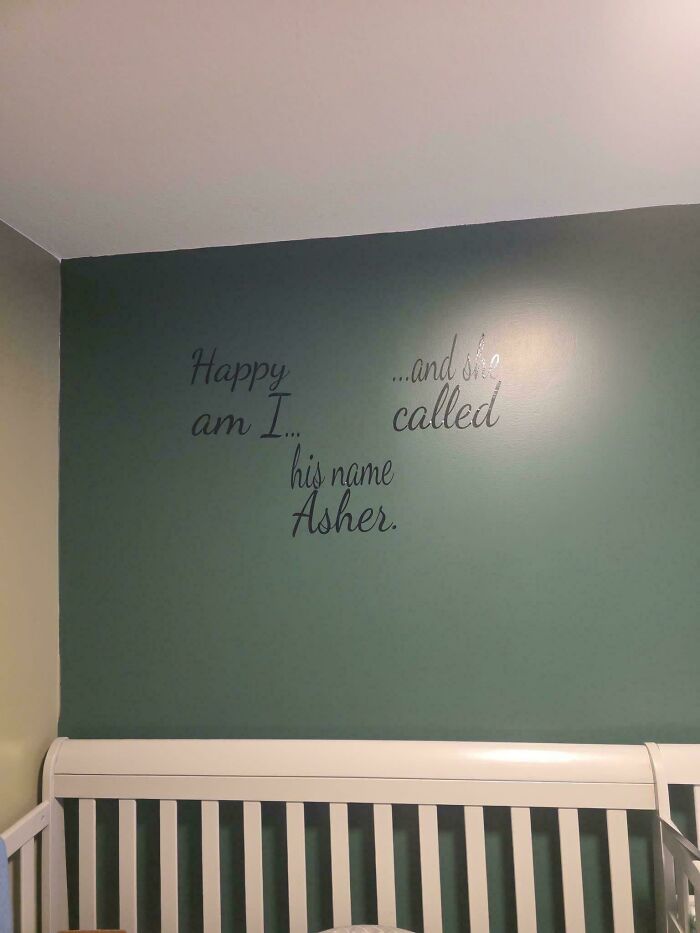Wall decal above white crib with poorly arranged text making it hard to read, illustrating terrible product design flaws.