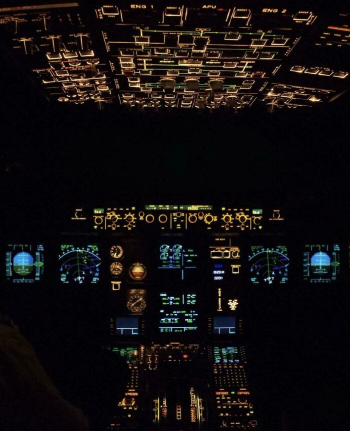 Illuminated airplane cockpit with glowing control panels in dark