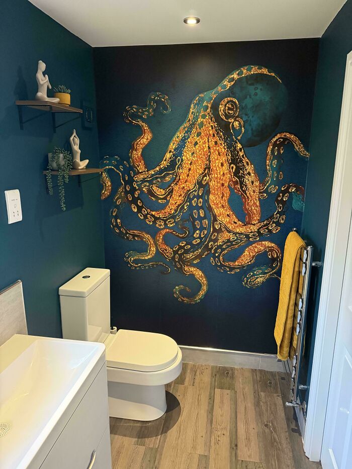A bathroom featuring a striking blue and gold octopus mural on the wall, a bold home decor project.