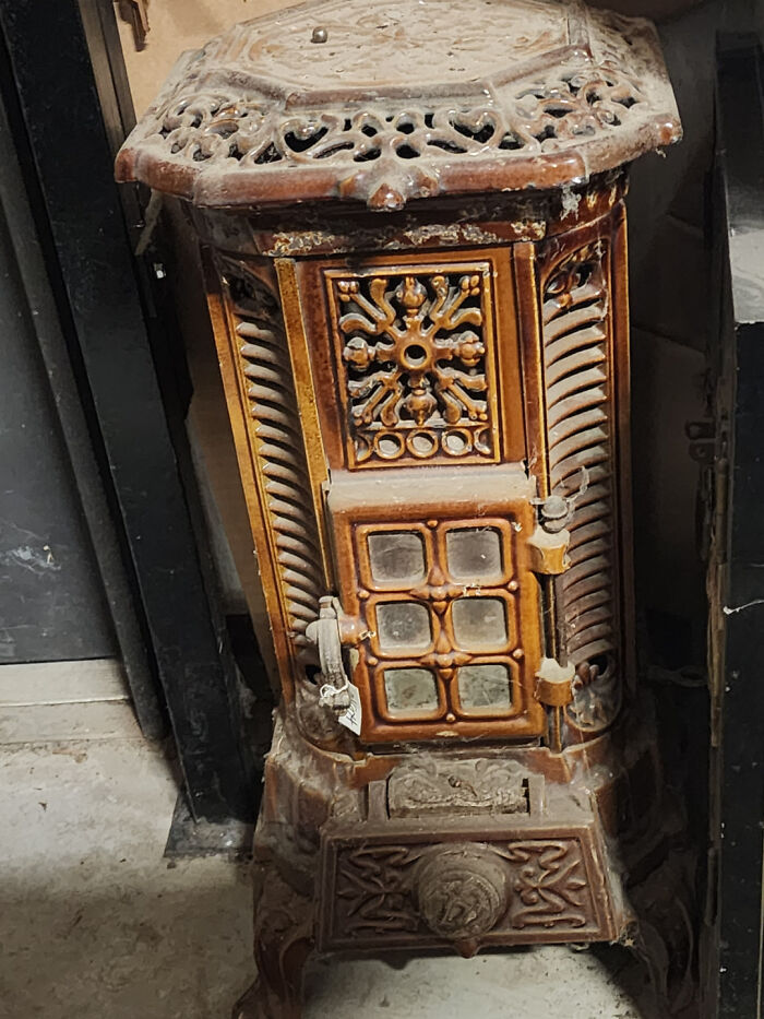 An ornate, antique cast-iron stove, a valuable item found through dumpster diving.