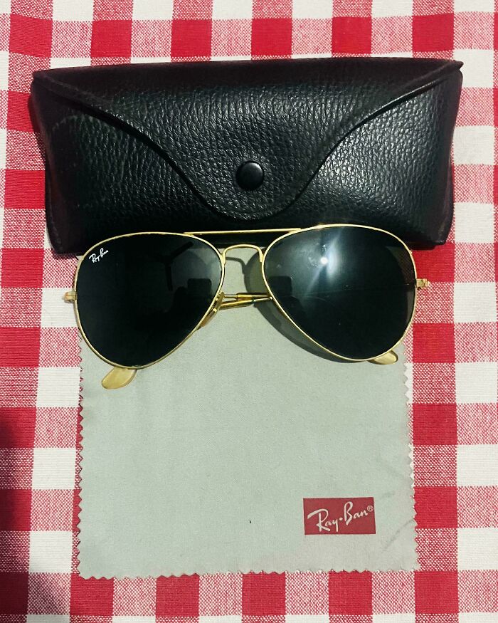 Ray-Ban aviator sunglasses with a black case and cleaning cloth on a red and white checkered surface. A Buy It For Life purchase.