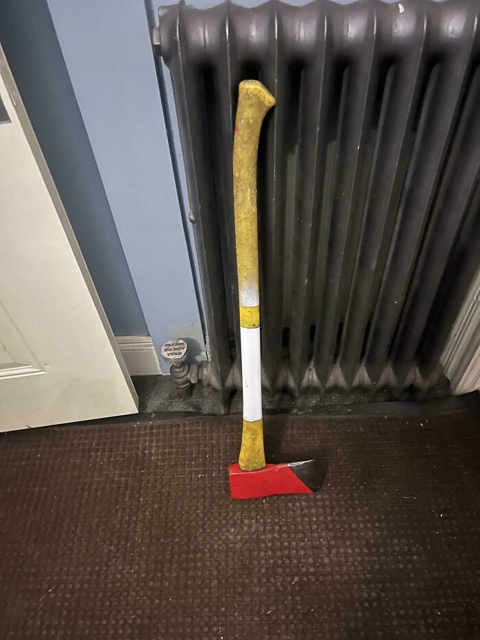 A red and yellow axe leaning against a dark radiator, part of a collection of mildly interesting pictures.