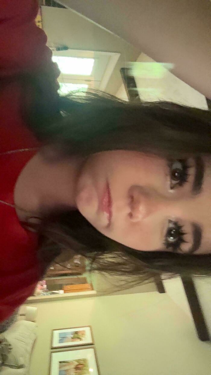 A close-up, upside-down selfie of a person with dark hair and long eyelashes, a picture amidst online lies.