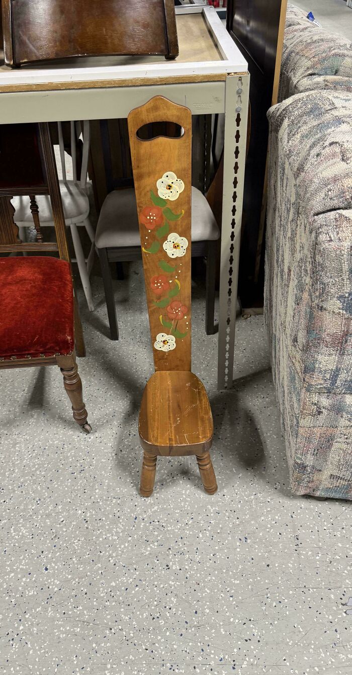 Wooden chair with an unusually tall backrest decorated with painted flowers, a strange pic that confuses people.